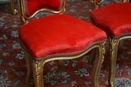 Gruppo di quattro sedie-poltrone dorate in velluto rosso stile Luigi XV