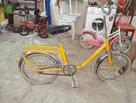 Bicicletta vintage gialla con telaio in metallo, sellino nero e portapacchi posteriore. Ruote di dim